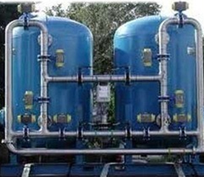 Twin blue pressure filter vessels connected by grey pipework and valves