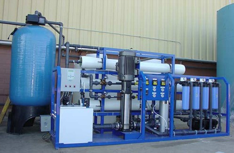 Skid-mounted industrial reverse osmosis unit with membrane pressure vessels, high-pressure pump and control panel